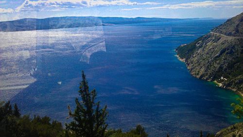 High angle view of sea and mountains against sky