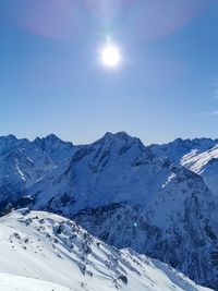 Scenic view of snowcapped mountains against blue sky