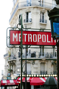 Road sign on street against buildings in city