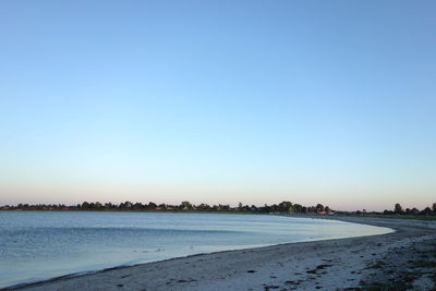 Scenic view of beach against clear blue sky