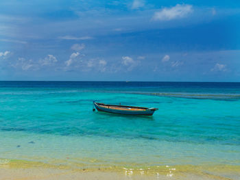 Boat in calm blue sea against sky