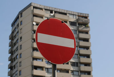 Skyscraper in the city, with a no entry traffic sign in front of it