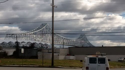 View of suspension bridge against cloudy sky