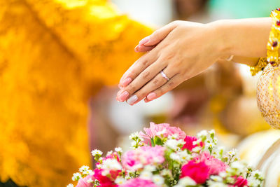 Midsection of people on flowering plant