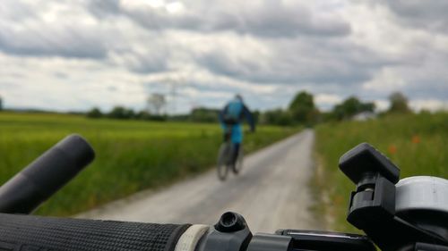 Close-up of man riding bicycle on road