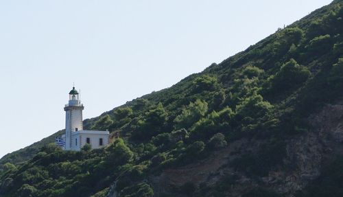 Lighthouse amidst buildings against clear sky