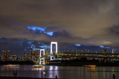 Rainbow bridge night view under twilight cloudy sky