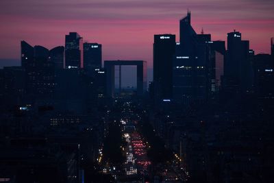 Silhouette buildings in city against sky at dusk