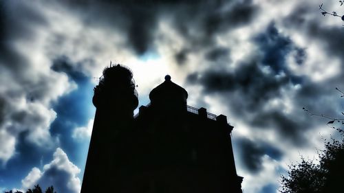 Low angle view of silhouette statue against cloudy sky