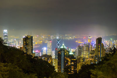 Illuminated cityscape against sky at night