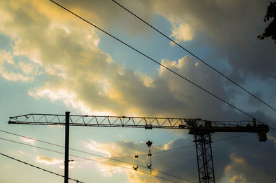 Low angle view of silhouette electricity pylon against sky