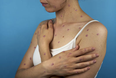 Low section of woman with hands against blue background