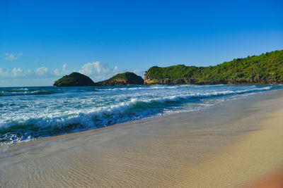 Scenic view of beach against clear blue sky