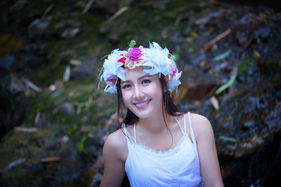 Close-up portrait of smiling young woman wearing wreath in forest