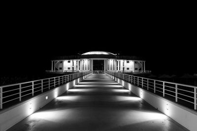 Empty illuminated bridge at night