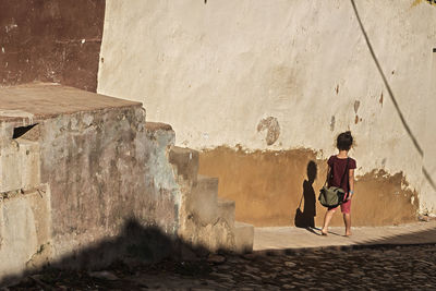 Rear view of women walking on wall