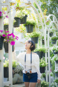 Young woman looking at flower pots in park