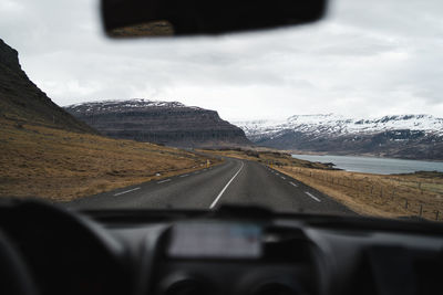 Road against sky seen through car windshield