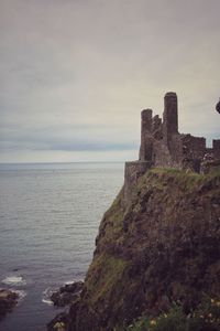 Old building by sea against sky