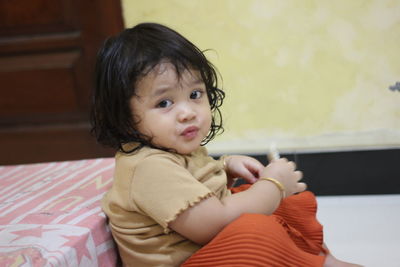 Cute baby girl sitting at home