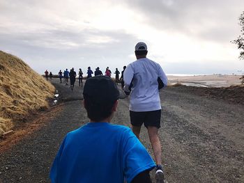 Rear view of people walking on land