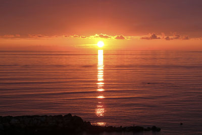 Scenic view of sea against romantic sky at sunset