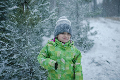 Cute boy standing outdoors during winter