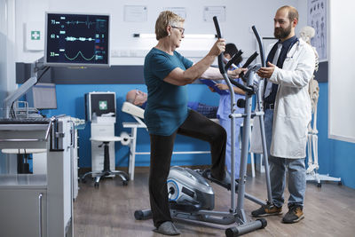 Low angle view of man using mobile phone in gym