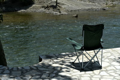 High angle view of empty chair at lake