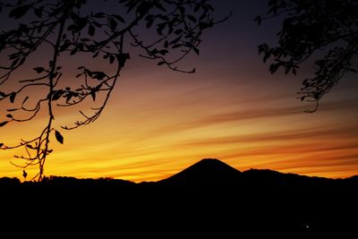 Scenic view of silhouette mountains against orange sky