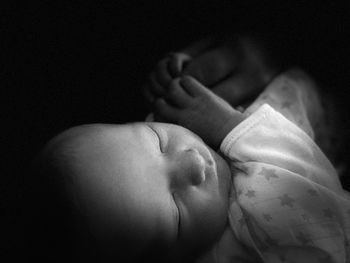 Close-up of baby feet against black background