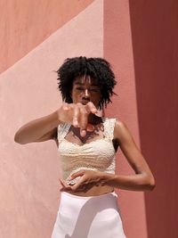 Young woman standing against wall