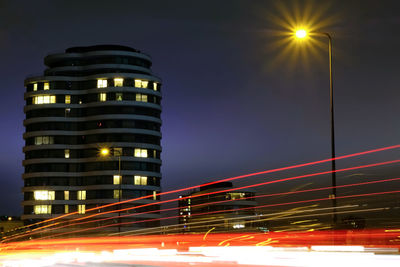 Light trails on street against sky at night