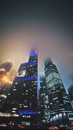 Low angle view of illuminated buildings against sky at night