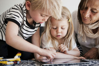 Grandmother with grandchildren using digital tablet