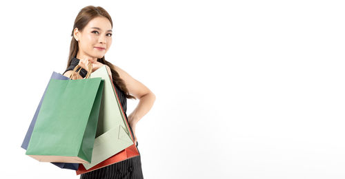 Portrait of smiling woman standing against white background