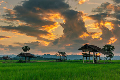 Built structure on field against sky during sunset