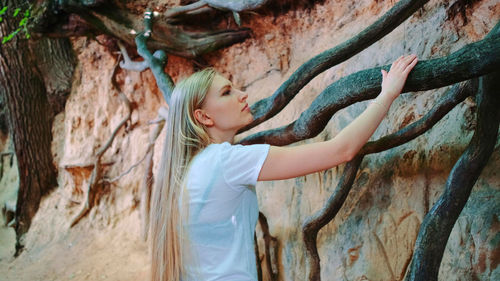 Side view of woman in tree trunk