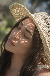 Pretty latina in straw hat enjoying sunshine