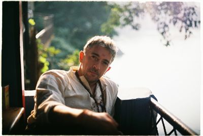 Portrait of man sitting on book