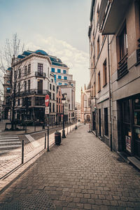 Street amidst buildings against sky in city