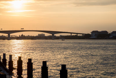 Bridge over river against sky during sunset