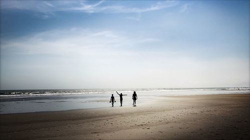 People on beach against sky