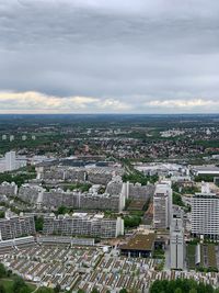 High angle view of city buildings against cloudy sky