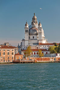 View of buildings by sea against sky