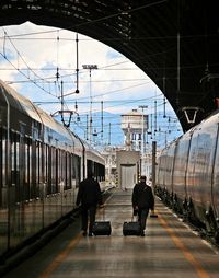 Rear view of people walking on train in city