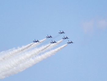 Low angle view of airplane flying against clear blue sky