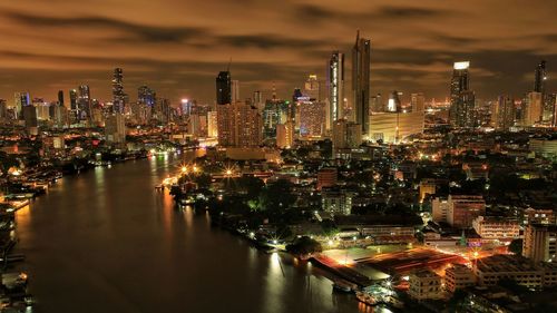 High angle view of illuminated buildings against sky at night