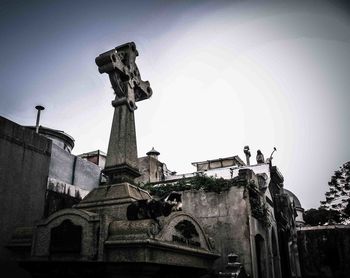 Low angle view of statues on building against sky