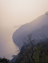 Scenic view of sea and mountains against sky